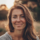 Une femme souriante en plein air au coucher du soleil.