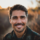 Homme souriant en plein air au coucher du soleil.